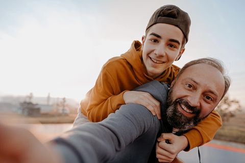 Sohn auf dem Rücken seines Vaters