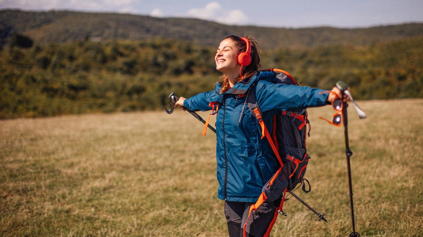Geschenke für Wanderer und Outdoorfans: Junge Wanderin auf einer Wiese