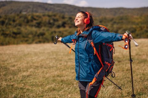 Geschenke für Wanderer und Outdoorfans: Junge Wanderin auf einer Wiese
