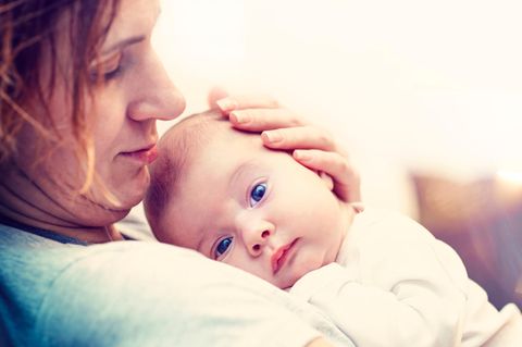 Zu Vitamin K Prophylaxe: Mutter mit Neugeborenem auf dem Arm