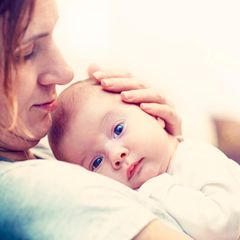 Zu Vitamin K Prophylaxe: Mutter mit Neugeborenem auf dem Arm
