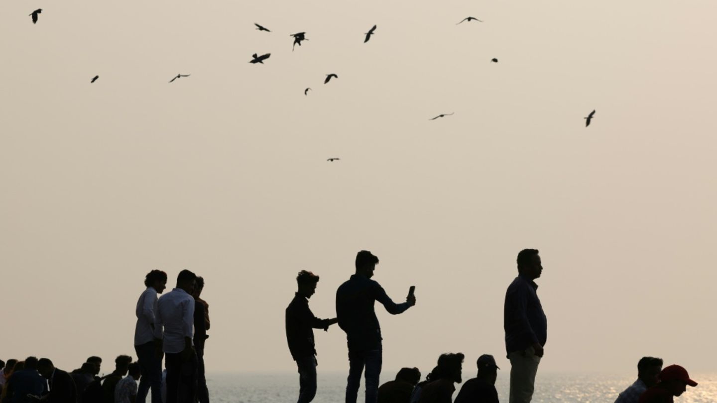 Menschen fotografieren mit ihren Smartphones das Meer.