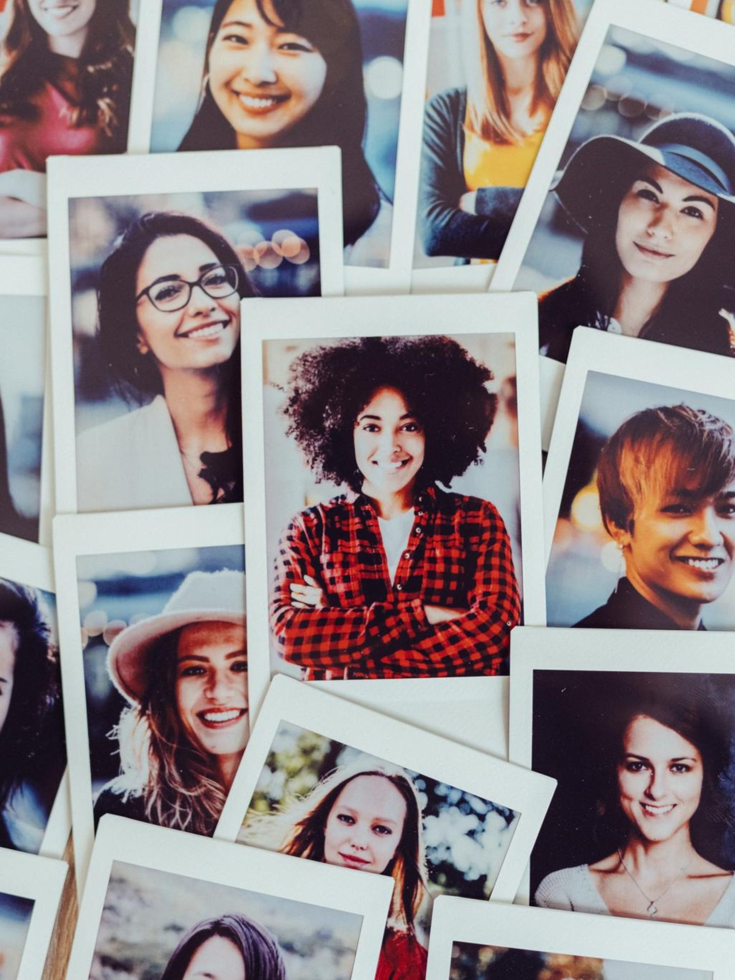 Symbolbild Dating-Apps: Fotos mit Portraits  von vielen verschiedenen Frauen unterschiedlicher Nationalitäten