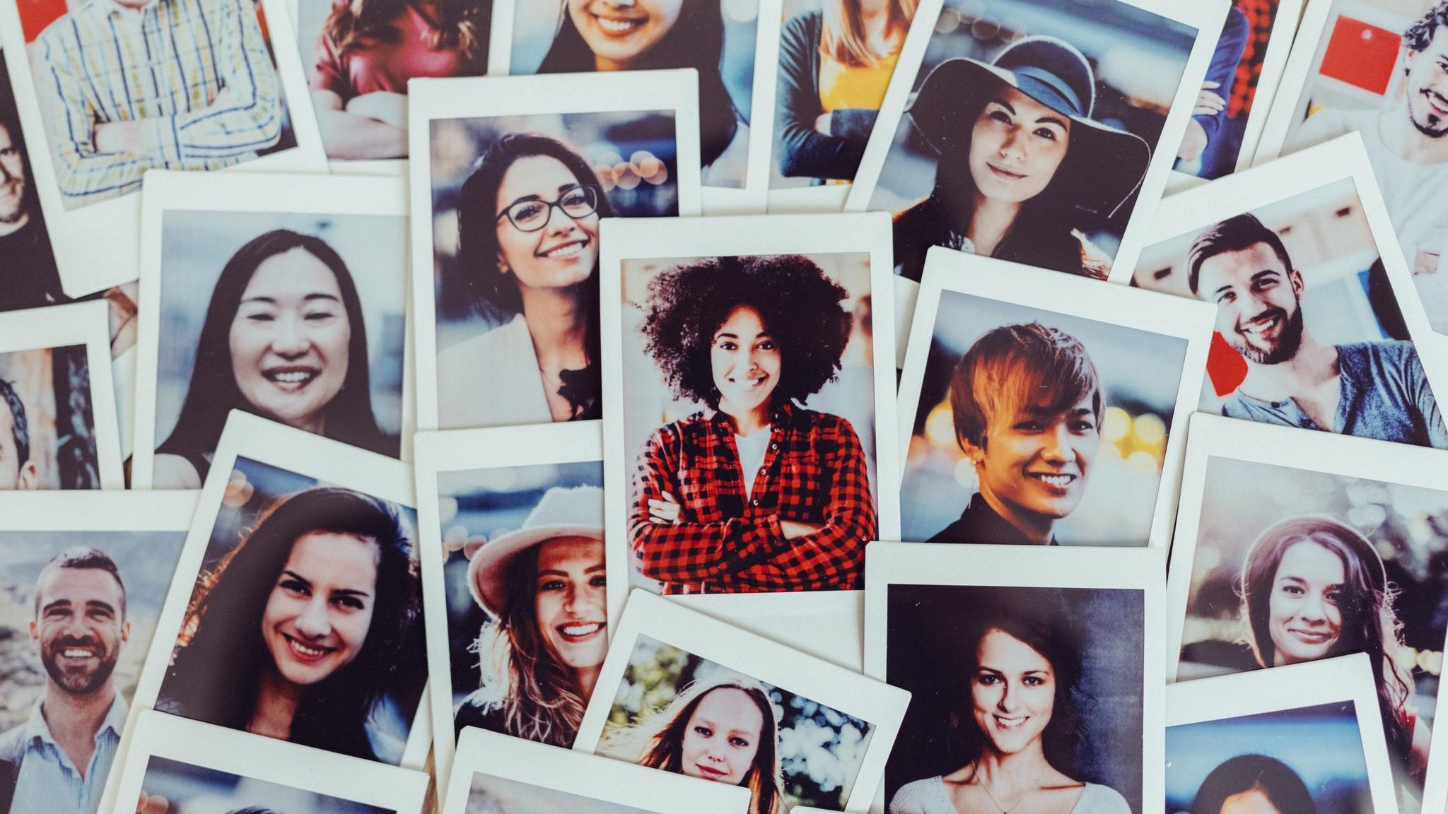 Symbolbild Dating-Apps: Fotos mit Portraits  von vielen verschiedenen Frauen unterschiedlicher Nationalitäten