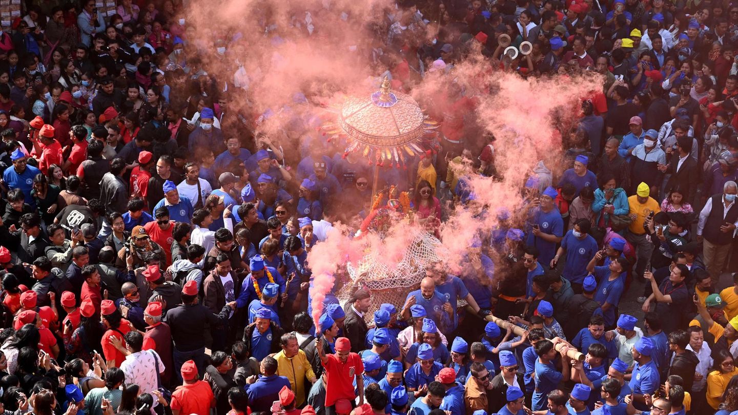Kathmandu, Nepal. Gläubige Hindus feiern in Kathmandu das Wagenfest. Dabei bahnen sich drei Wagen zu Ehren der Göttinnen Kankeshwori, Wanchu Bhadrakali und Lumadi Bhadrakali einen Weg durch die Menschenmassen. Traditionell tagen die Feiernden zu diesem Anlass Rot, Blau und Gelb.