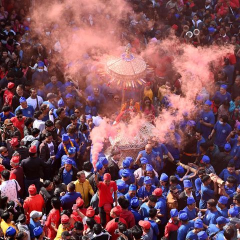 Kathmandu, Nepal. Gläubige Hindus feiern in Kathmandu das Wagenfest. Dabei bahnen sich drei Wagen zu Ehren der Göttinnen Kankeshwori, Wanchu Bhadrakali und Lumadi Bhadrakali einen Weg durch die Menschenmassen. Traditionell tagen die Feiernden zu diesem Anlass Rot, Blau und Gelb.