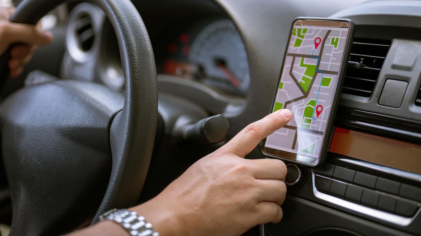 Fahrer mit GPS-Navigation im Handy während der Fahrt Auto