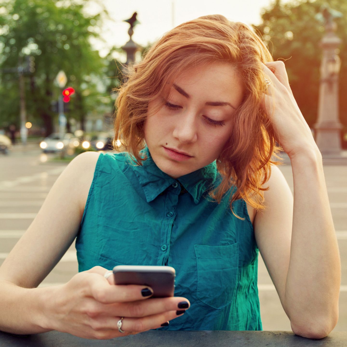 Eine Frau schaut frustriert auf ihr iPhone