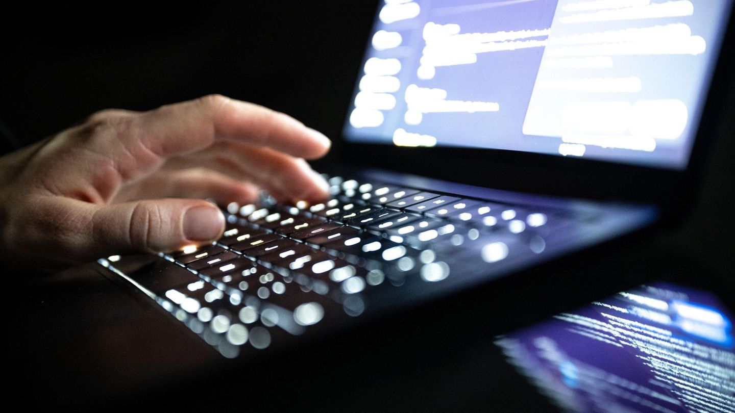 Eine linke Männerhand tippt auf der Tastatur eines Laptops – Symbolbid für Cyberangriffe