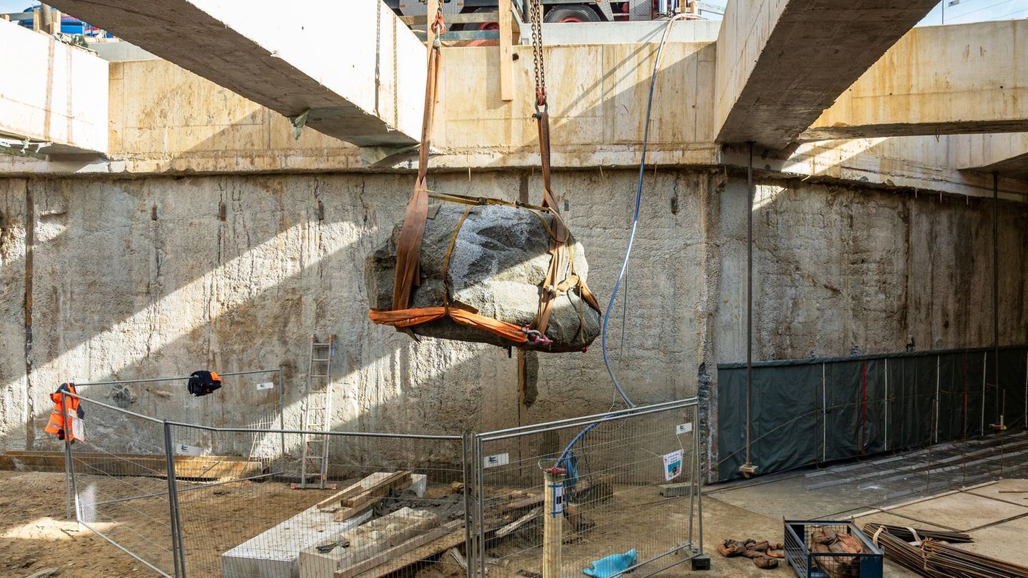 Der Findling wird aus der Baugrube gehoben. Foto: Hochbahn/dpa