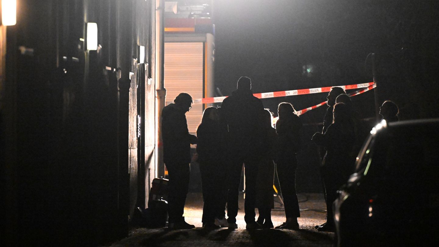 Polizeibeamte, Kriminalpolizei, Spurensicherung und Staatsanwaltschaft stehen vor einem Haus, in dem eine Frau tot aufgefunden w