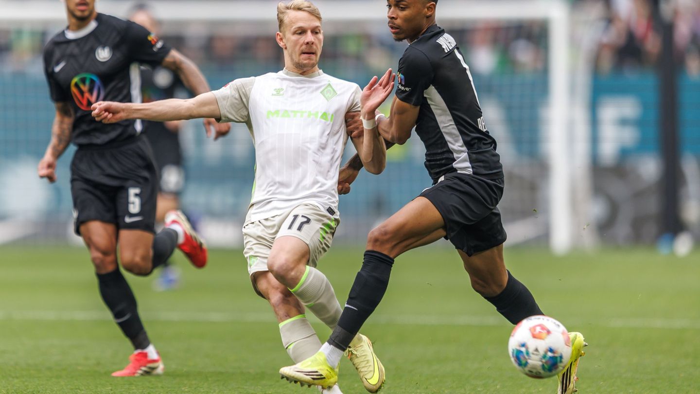 Werders Marco Grüll (l) wird von Wolfsburgs Jeanuel Belocian bedrängt. Foto: Andreas Gora/dpa