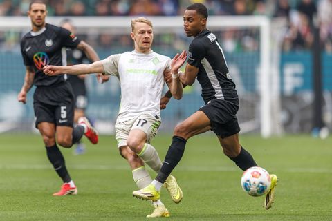 Werders Marco Grüll (l) wird von Wolfsburgs Jeanuel Belocian bedrängt. Foto: Andreas Gora/dpa