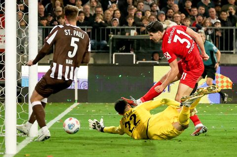 Ein Fehler mit Folgen: Freiburgs Igor Matanovic (r) nutzt den Patzer von St. Paulis Torwart Nikola Vasilj (M.) Foto: Christian C