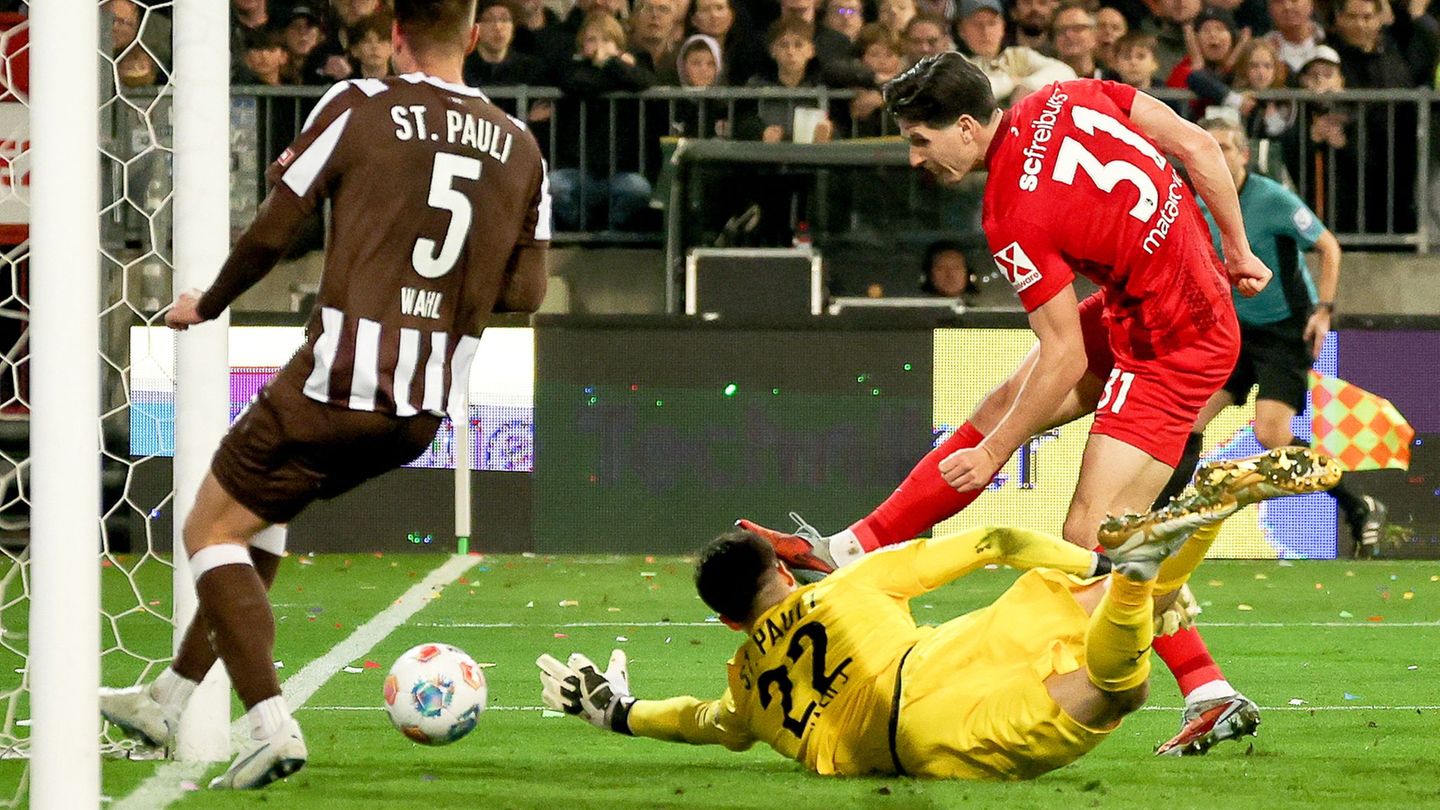 Ein Fehler mit Folgen: Freiburgs Igor Matanovic (r) nutzt den Patzer von St. Paulis Torwart Nikola Vasilj (M.) Foto: Christian C