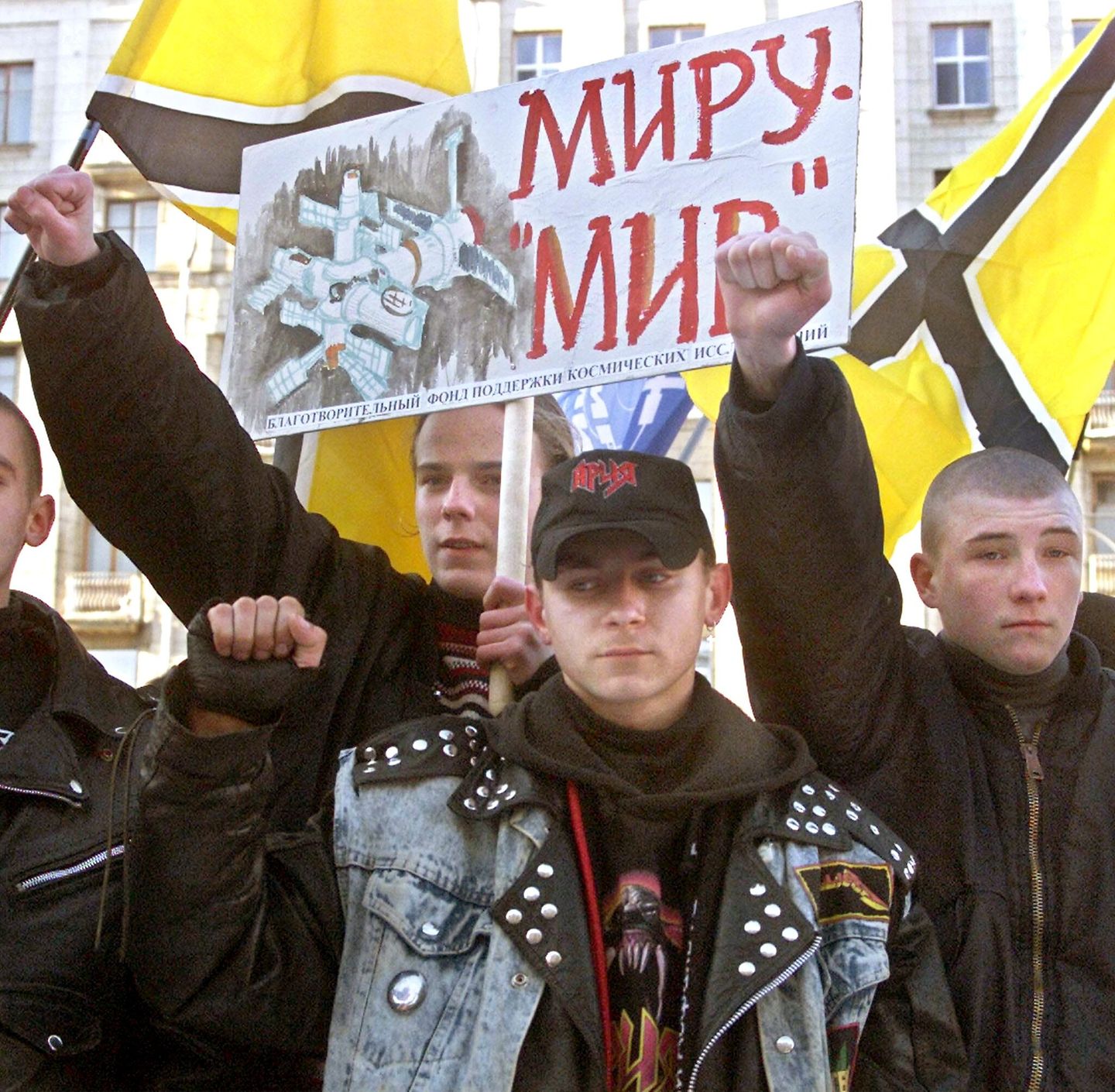 Eine Gruppe Männer protestiert mit erhobenen Händen und Plakaten