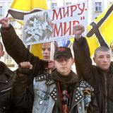 Eine Gruppe Männer protestiert mit erhobenen Händen und Plakaten