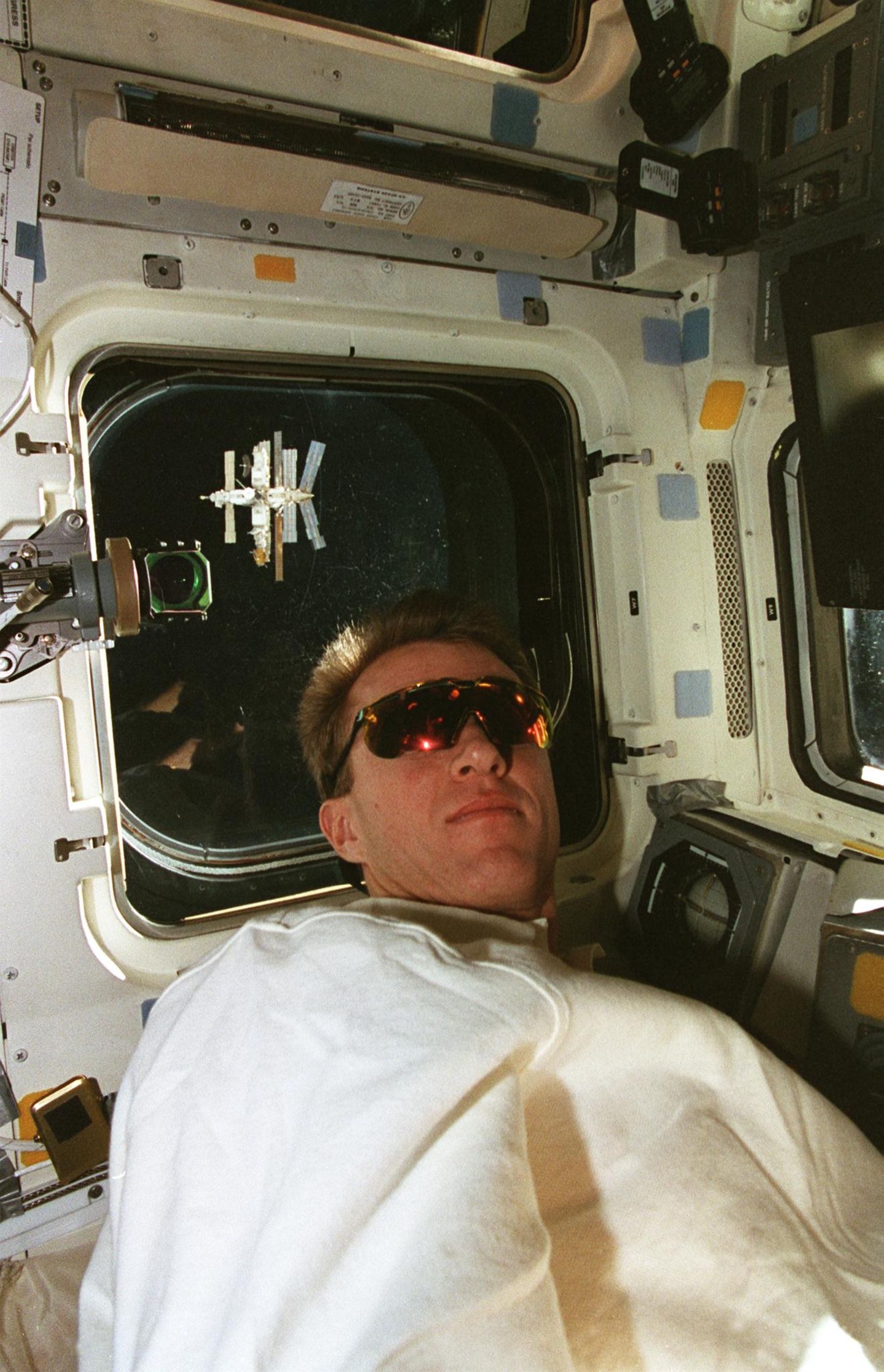Astronaut Brent W. Jett am Fenster des Raumschiffs Atlantis, die Mir ist im Weltall zu sehen
