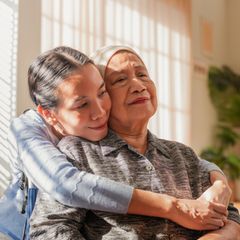 Eine krebskranke Mutter wird von ihrer Tochter umarmt