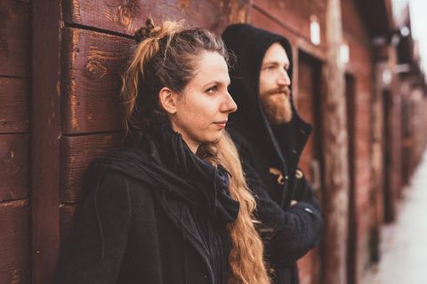 Affäre: Mann und Frau angelehnt an einer Holzwand