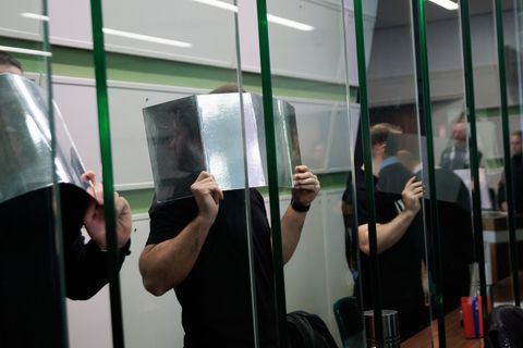 Angeklagte verdecken ihre Gesichter im Gerichtssaal beim Prozess wegen mehrerer Fahrzeugbrände. (Archivbild) Foto: Carsten Koall