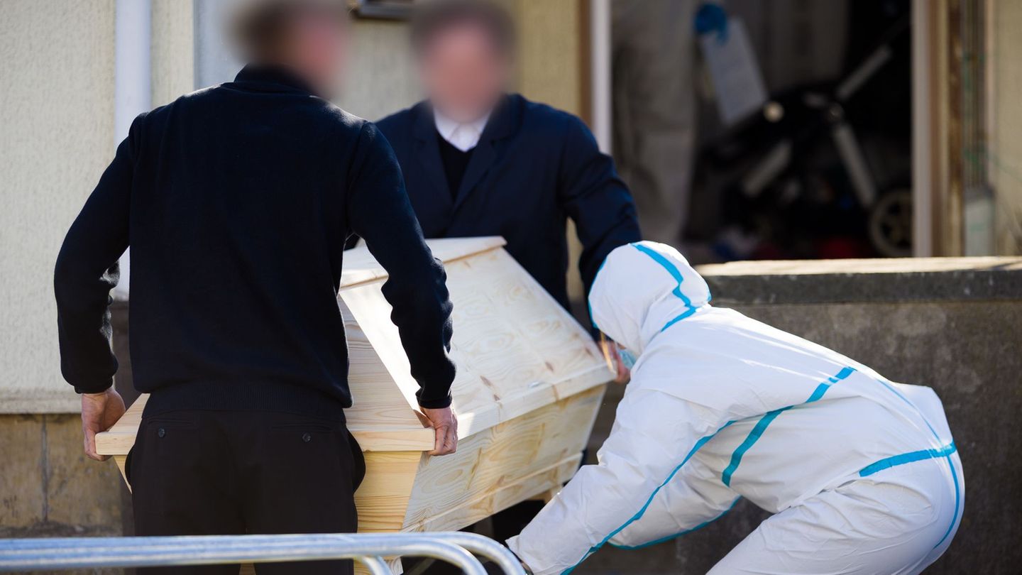 Bestatter verließen mit einem Sarg das Haus. Foto: Moritz Frankenberg/dpa