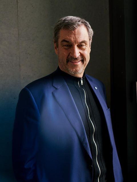 Markus Söder schaut in die Kamera, hinter einer Scheibe sieht man den CSU-Schriftzug