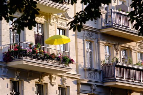 Ein gelber Sonnenschirm auf dem Balkon einer Luxus-Immobilie