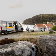 Ein Camper mit Van parkt an einer Klippe am Meer