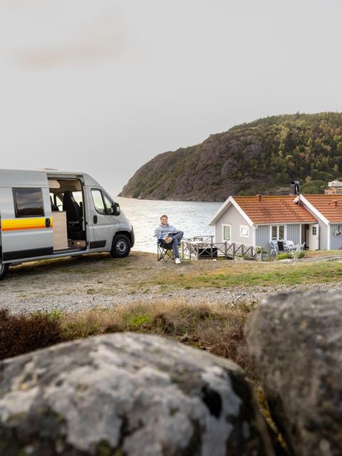 Ein Camper mit Van parkt an einer Klippe am Meer
