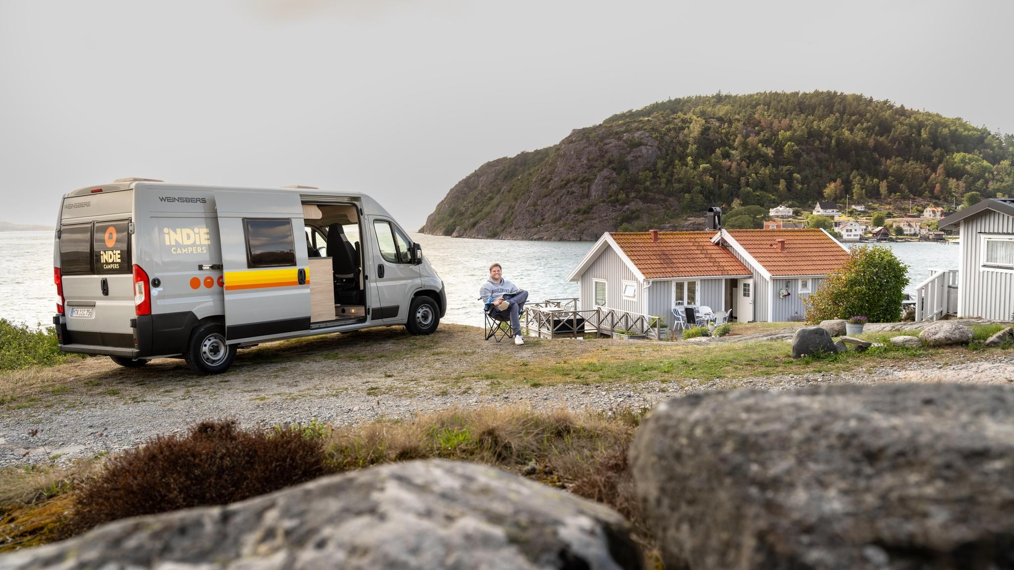 Ein Camper mit Van parkt an einer Klippe am Meer