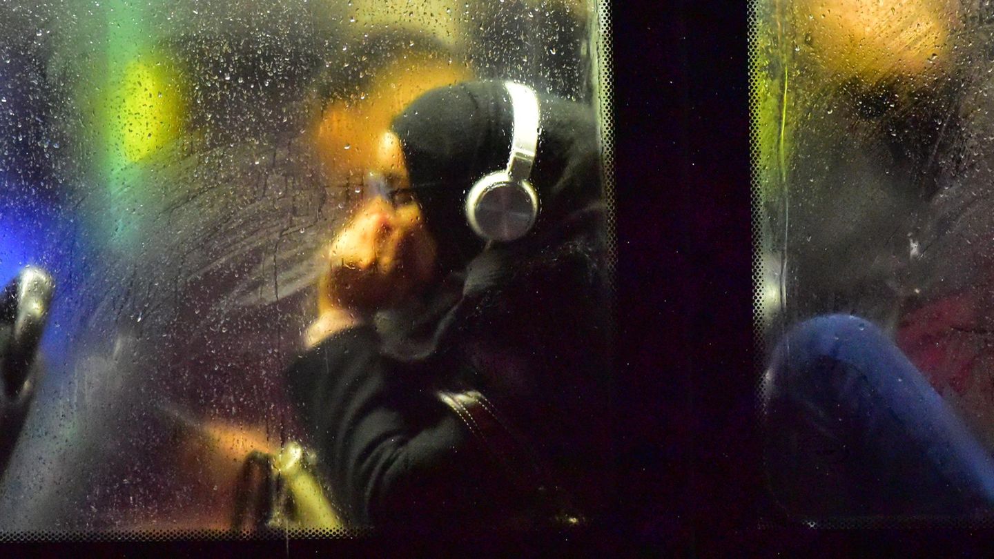 Frau mit Kopfhörern im Bus