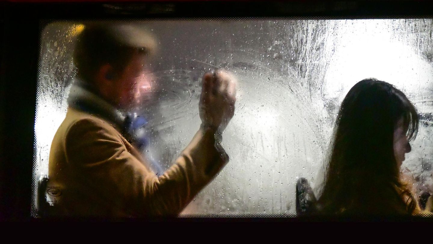 Mann sitzt hinter Frau im Bus