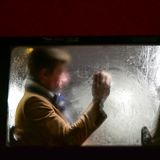 Mann sitzt hinter Frau im Bus