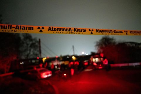 Ein Flatterband, auf dem „Atommüll-Alarm“ steht, hängt vor der Mahnwache vor der A42 in Duisburg
