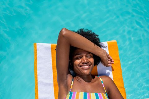 Urlaub: Frau auf Luftmatratze im Pool