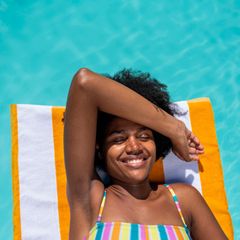 Urlaub: Frau auf Luftmatratze im Pool