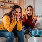 Zwei Frauen auf einem Sofa, die eine scheint sehr viel zu reden, die andere kann es nicht mehr hören