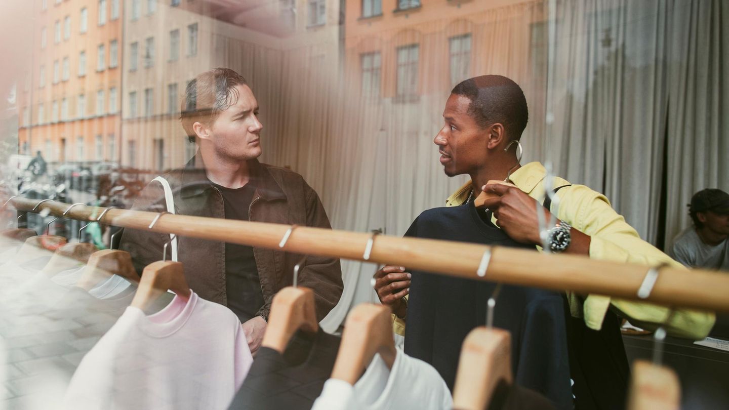 Zwei Männer in einem Geschäft schauen sich Kleidung an