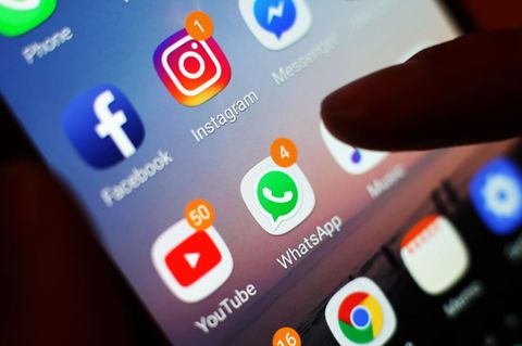 Ein Smartphone-Display mit Symbolen von Social-Media-Apps, darunter Facebook, Instagram, YouTube und WhatsApp