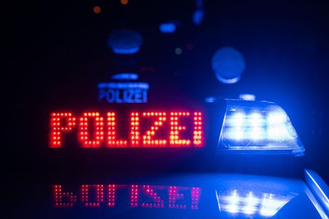 Auf einem Polizeifahrzeug leuchtet die Aufschrift Polizei