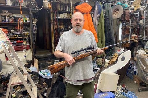 Der Trump- und Waffennarr Jim Klein trägt ein Gewehr in seinen Armen.