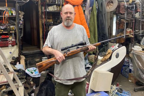 Der Trump- und Waffennarr Jim Klein trägt ein Gewehr in seinen Armen.