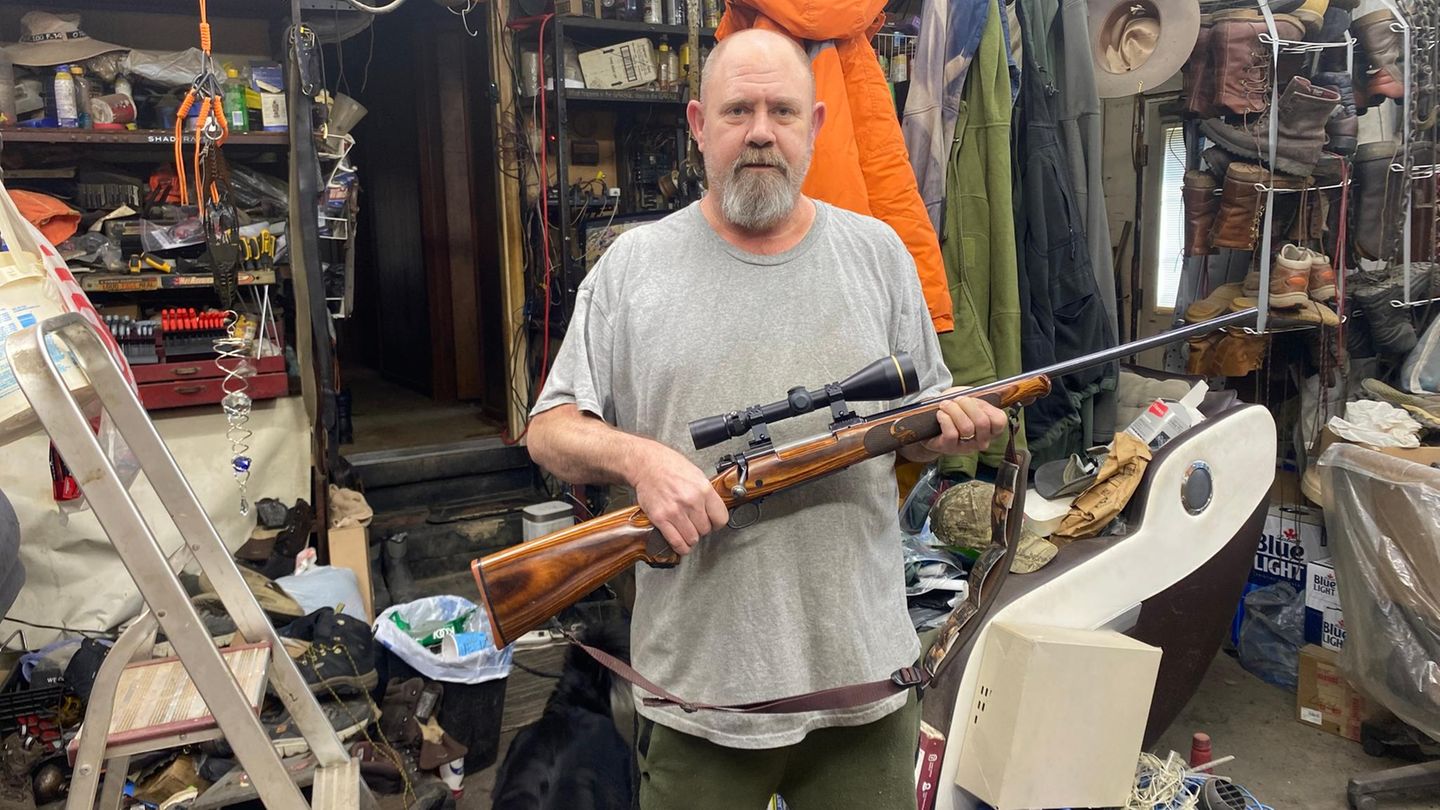 Der Trump- und Waffennarr Jim Klein trägt ein Gewehr in seinen Armen.