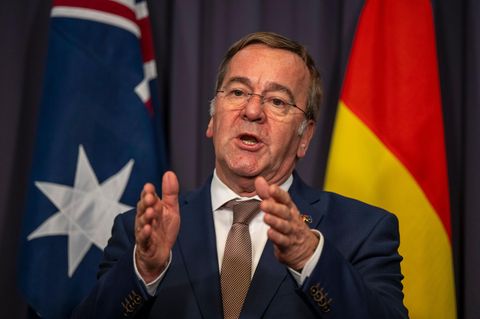 Boris Pistorius gestikuliert während einer Rede, während hinter ihm eine australische und eine deutsche Flagge hängen