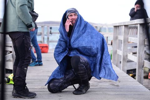 Robert Marc Lehmann geht auf Tuchfühlung mit einem gestrandeten Wal in der Ostsee. Foto: Daniel Bockwoldt/dpa