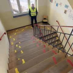 Ein Sicherheitsdienst-Mitarbeiter steht an einer Schultreppe.