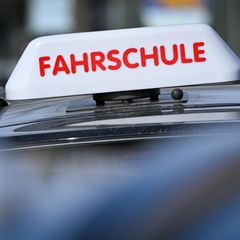 Fahrschulenschild auf einem Autodach (Aufmacherbild für Führerscheinquiz)