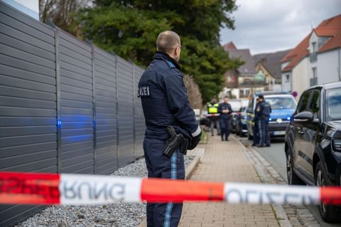 Ein Polizist steht hinter einem „Polizei°-Absperrband in Pommelsbrunn bei Nürnberg