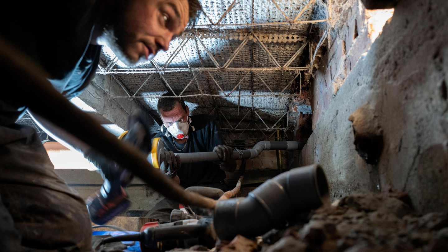 Zwei Männer reparieren Abwasserrohre